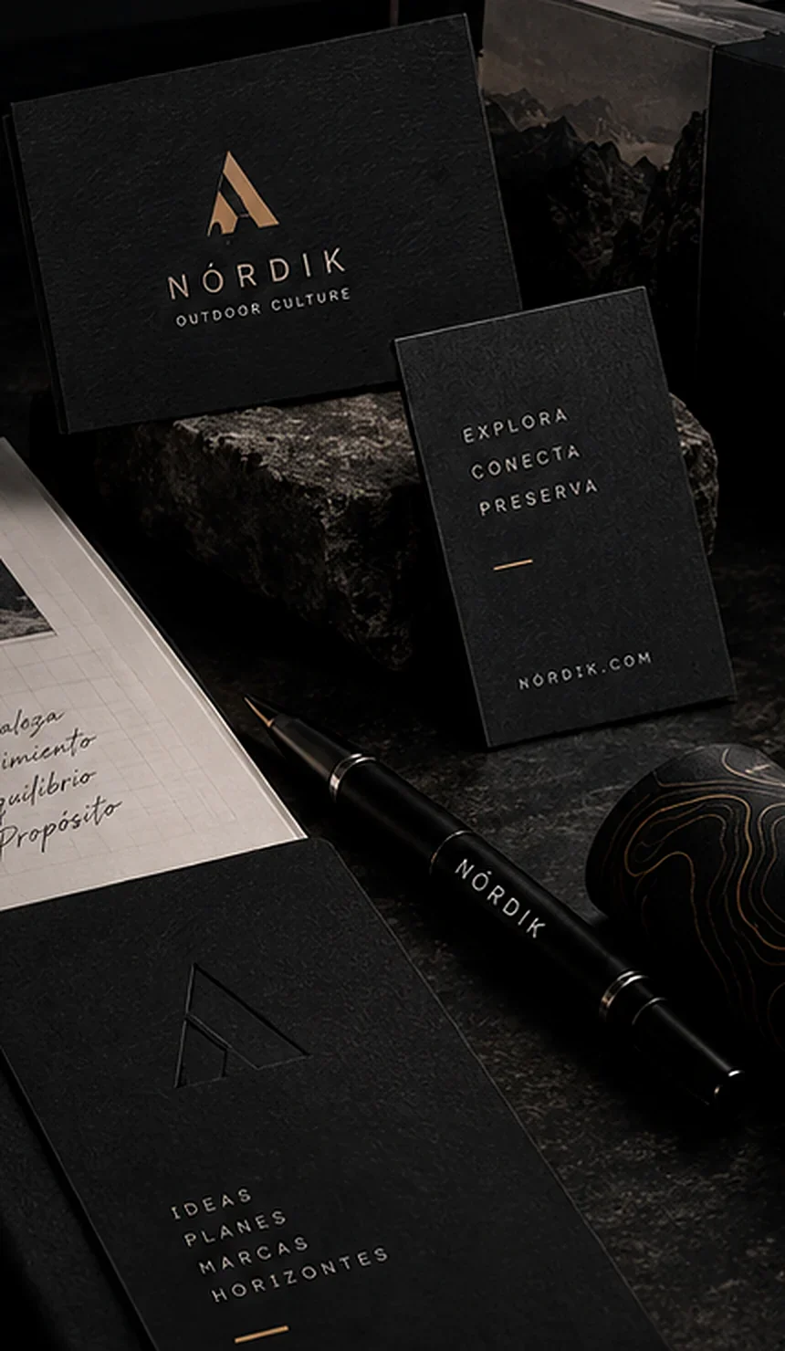 Papelería de una identidad visual de ejemplo sobre mesa oscura