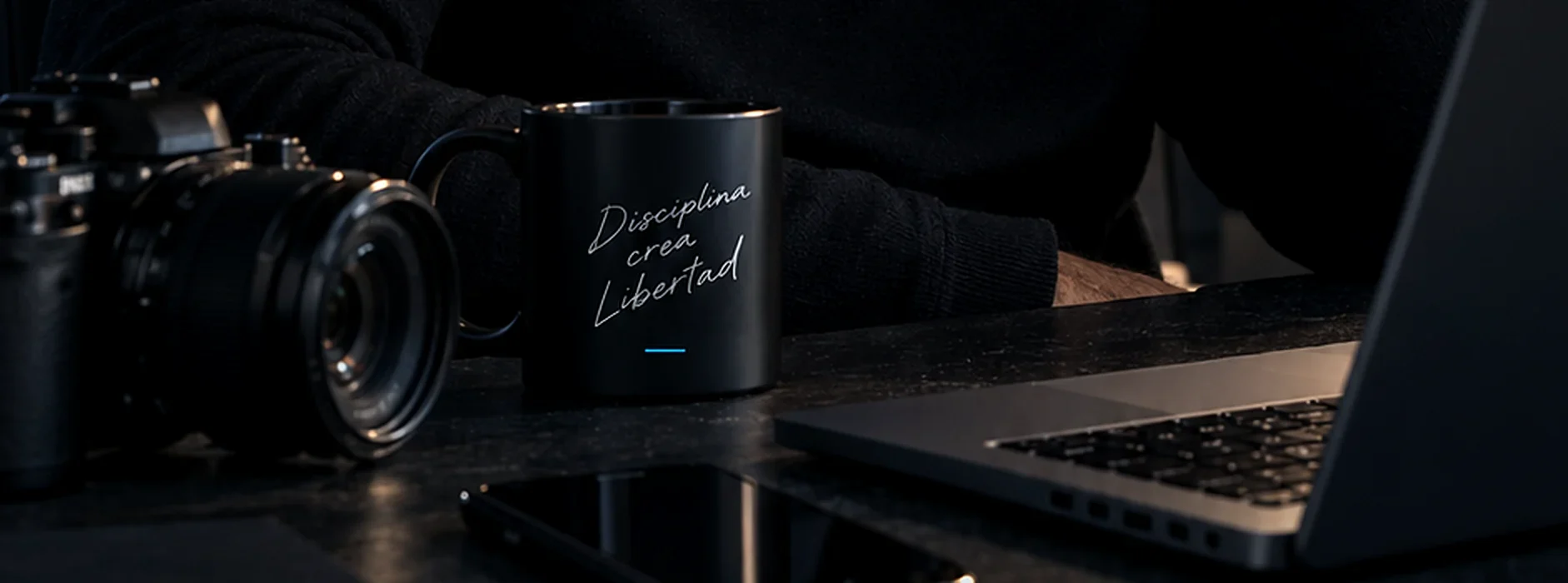 Escritorio con cámara, taza y portátil de trabajo